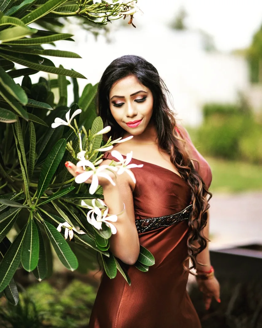 Nibedita with white frangipani flowers in soft daylight