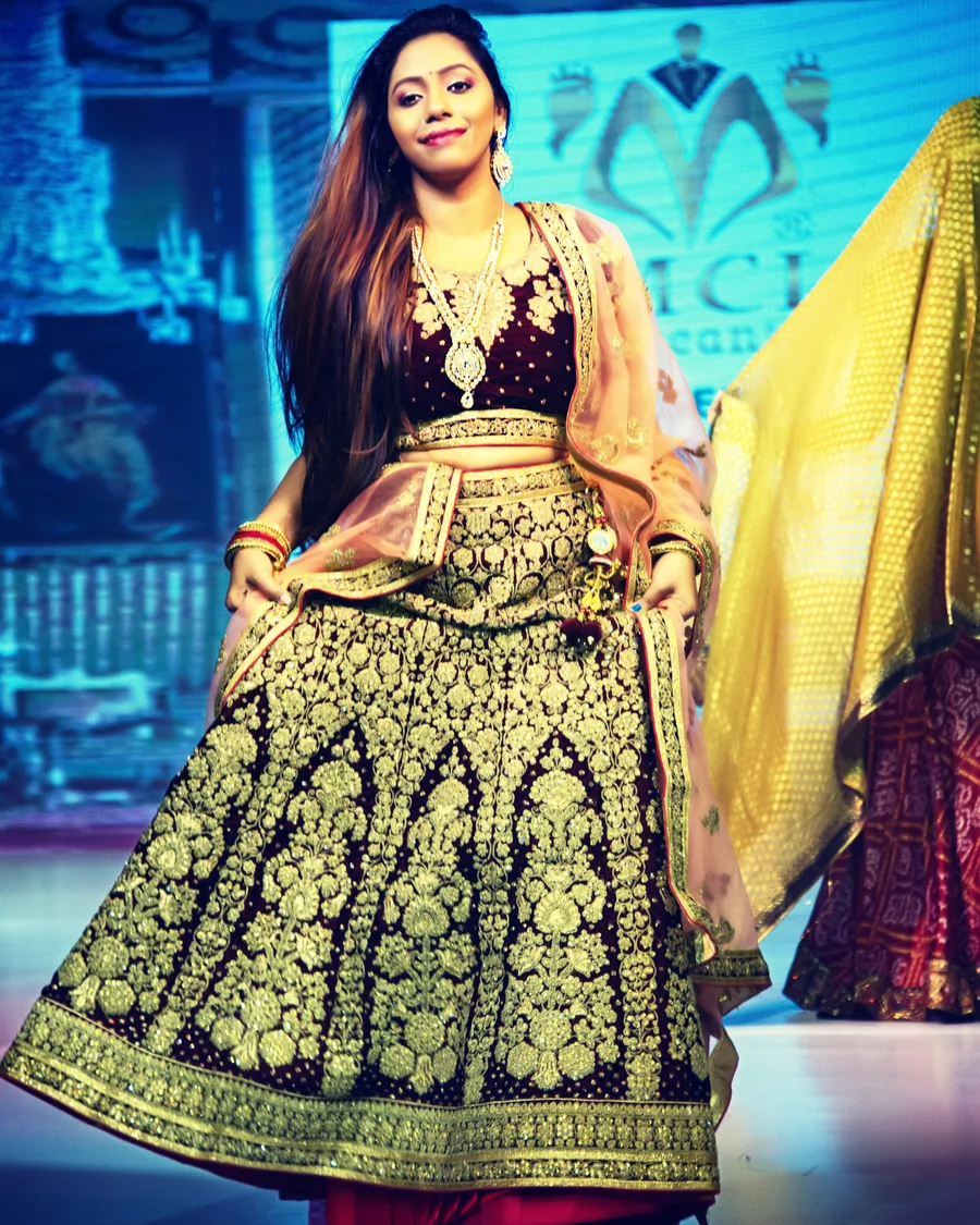 Nibedita on the runway in an embroidered maroon lehenga