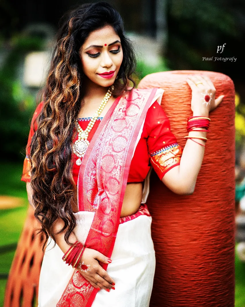 Portrait of Nibedita in a red and white saree